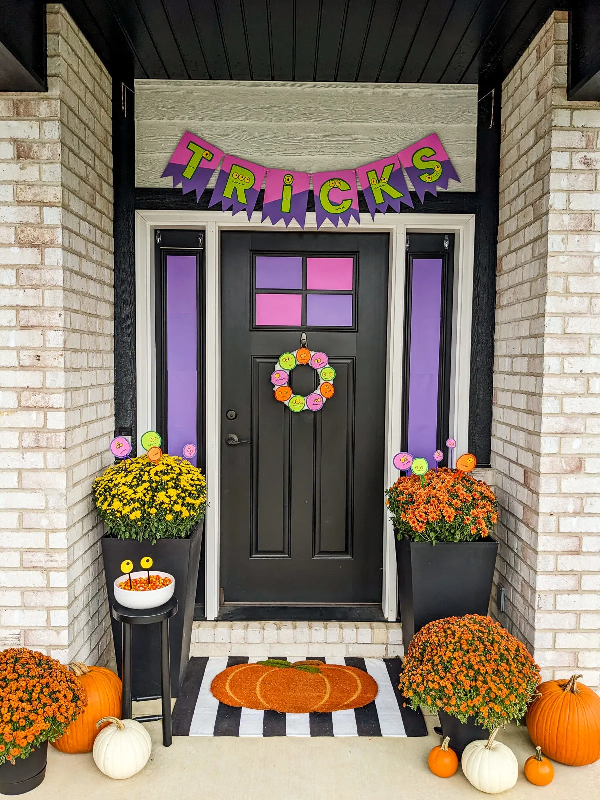 Monster DIY Halloween Decorations on a front porch with pumpkins and mums