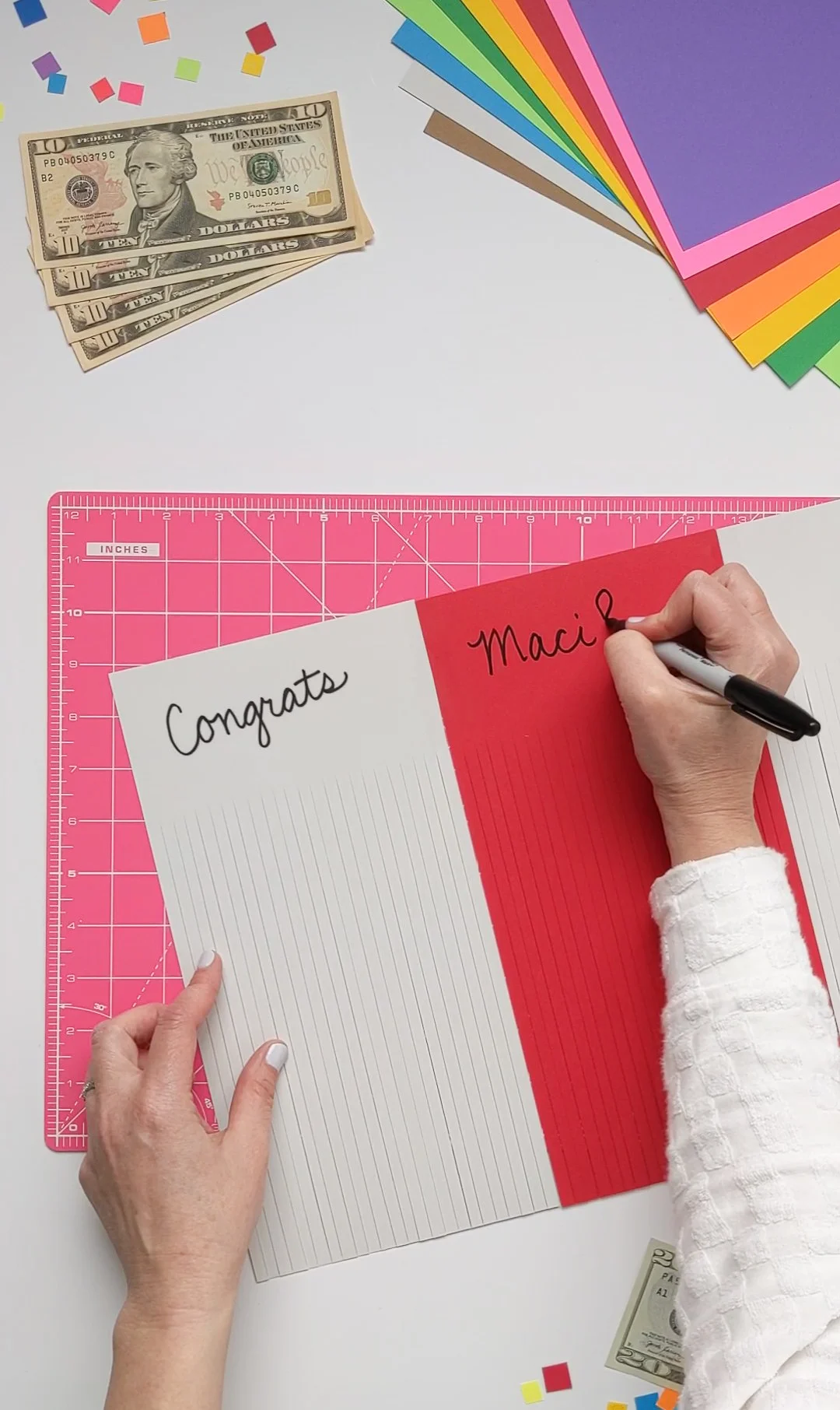 Writing a hidden message inside paper tassels that graduates will see when they unroll their money gift