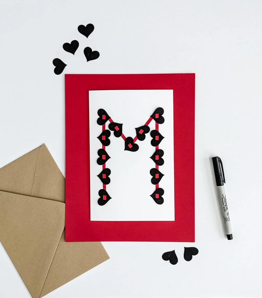 Handmade valentine for teens with black hearts and red strips of their first initial