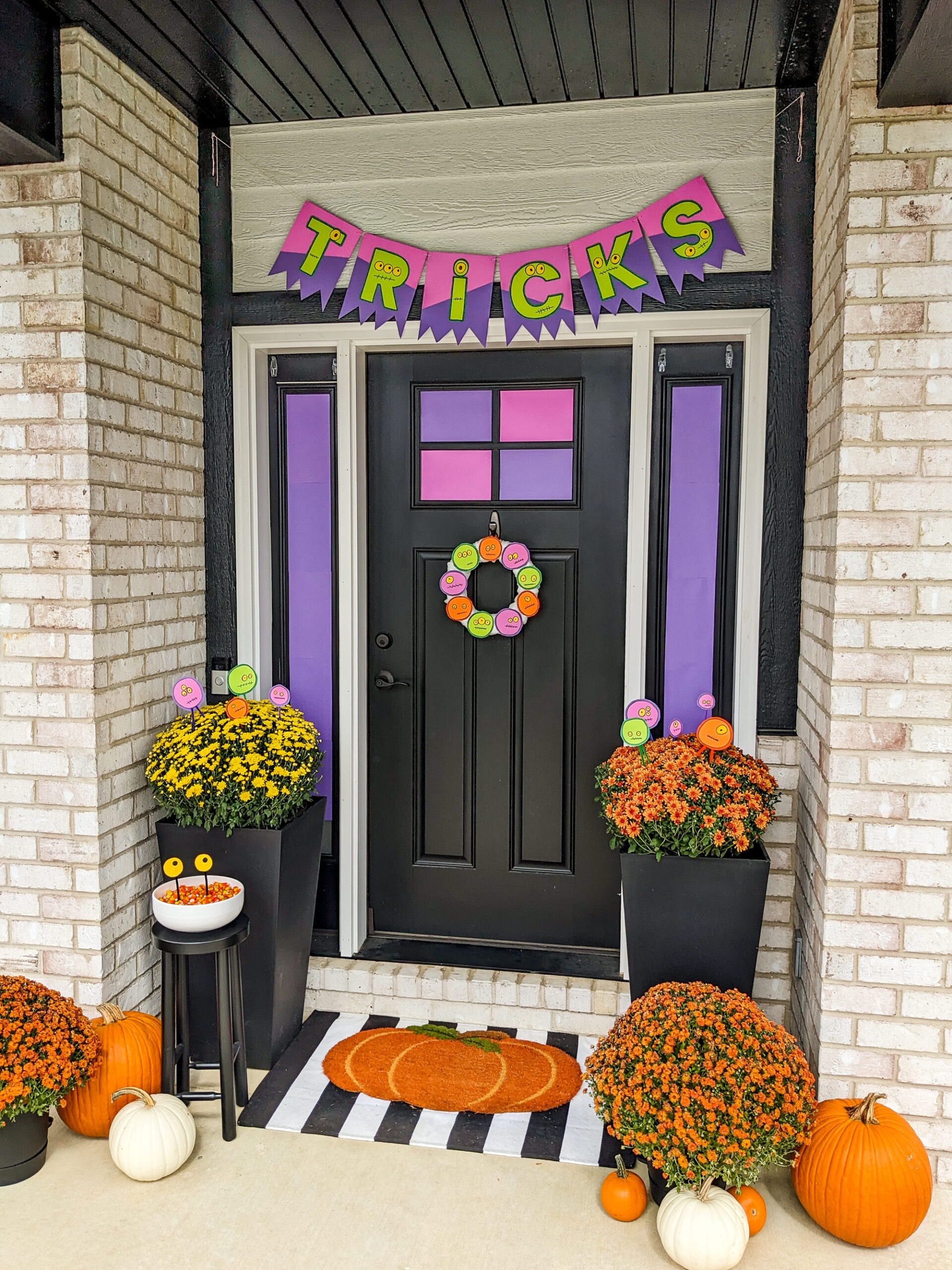 Monster DIY Halloween Decorations on a front porch with pumpkins and mums