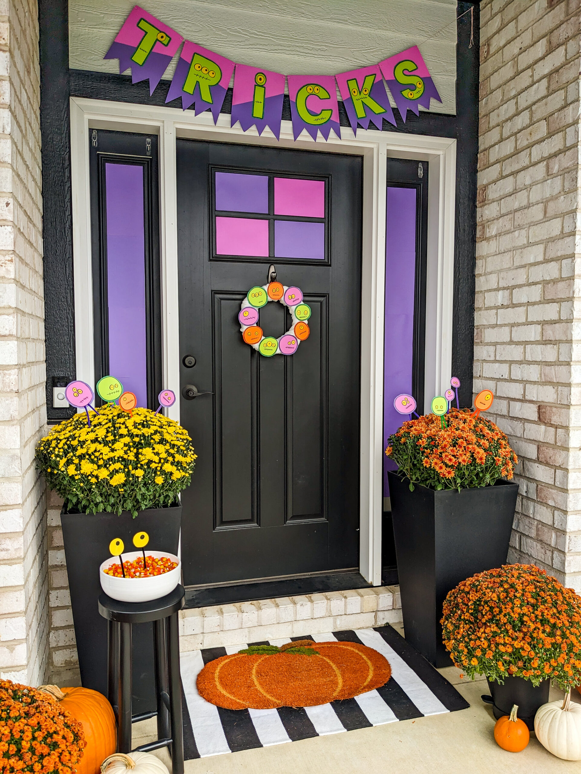 Monster DIY Halloween Decorations on a front porch with pumpkins and mums